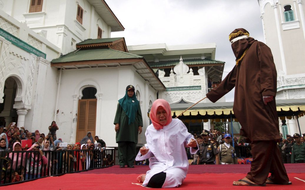 Жінка кричить під час покарання у мечеті в міста Банда-Ачех індонезійської провінції Ачех. Нур Еліта отримала п&#039;ять ударів палицею за дошлюбні статеві контакти з її бойфрендом. Ачех є єдиною провінцією в Індонезії, де правлять закони шаріату. / © Reuters