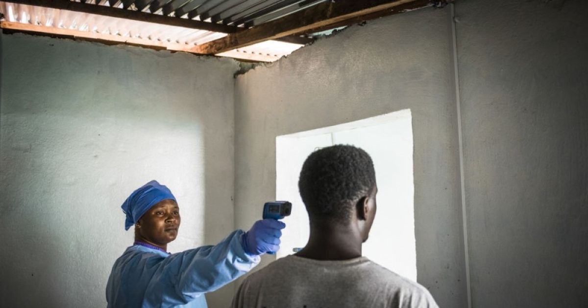 Победитель в номинации &laquo;Фотожурналист года&raquo;. Медсестра одной из клиник в Монровии измеряет температуру пациента с помощью инфракрасного термометра. Фото Дэниэля Береулака (The New York Times)