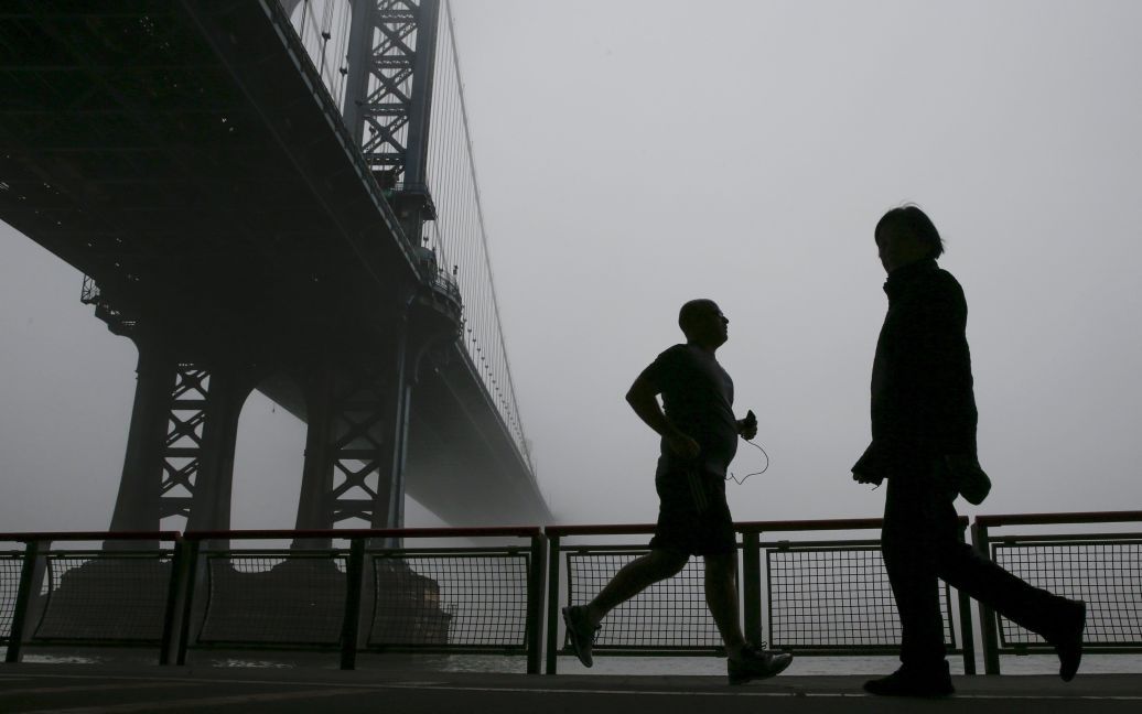 Людей видно через туман, який накрив Манхеттенський міст у Нью-Йорку. / © Reuters