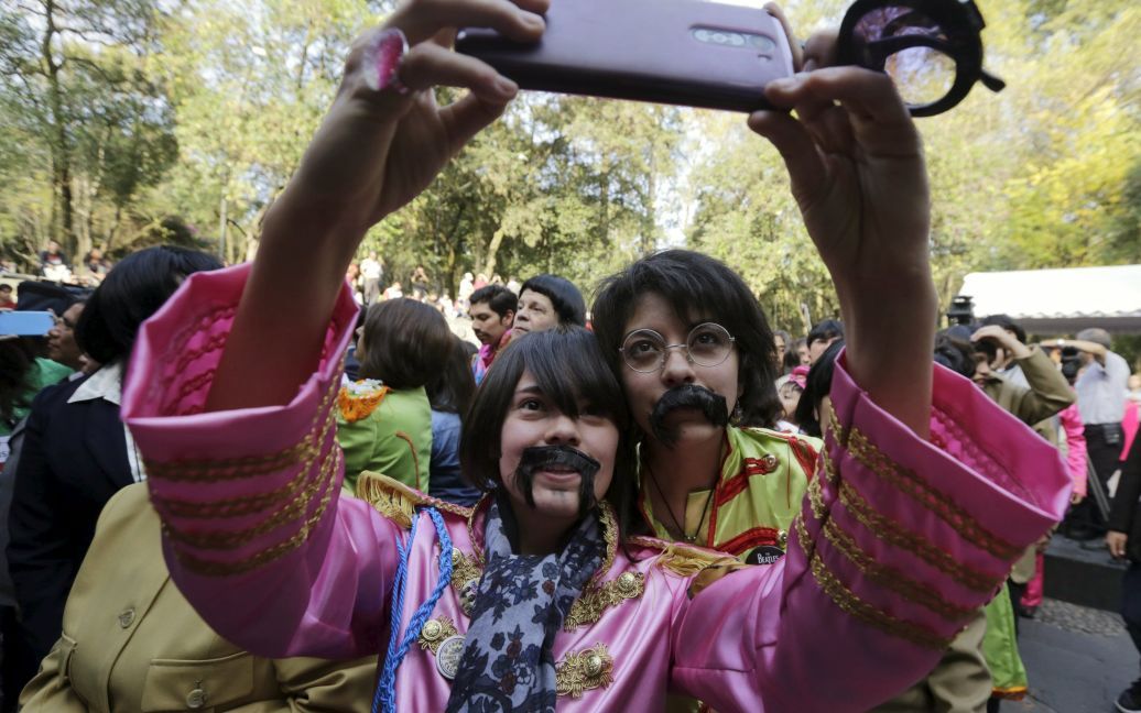Жінка, одягнена в учасника гурту The Beatles, робить селфі при спробі встановити світовий рекорд Гіннеса з найбільшого числа людей, одягнених, як The Beatles, в парку в Мехіко, Мексика. / © Reuters