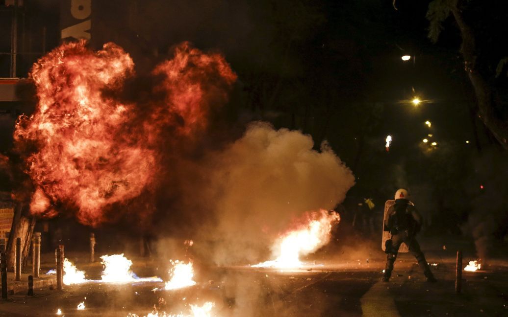 Бензинова бомба вибухає поруч з офіцером поліції під час зіткнень з демонстрантами у річницю загибелі 15-річного студента Александроса Грігоропулоса. Студент загинув під час масових заворушень в Афінах у 2008 році. Він був застрелений поліцейським. / © Reuters