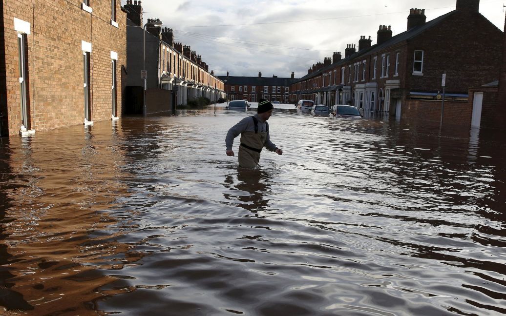 Чоловік пробирається через паводкові води на вулиці в Карлайлі, Великобританія. Після тривалих дощів північну Англію накрило повенями, через що екстренні служби евакуювали жителів з їхніх будинків. / © Reuters
