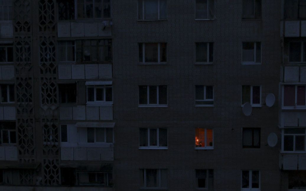 Одинокий свет освещает комнату в темное время суток в жилом здании в Симферополе, Крым. Оккупированный полуостров полагается на аварийные генераторы, чтобы удовлетворить свои потребности в электроэнергии после того, как неизвестные диверсанты взорвали опоры электроснабжения в минувшие выходные. / © Reuters