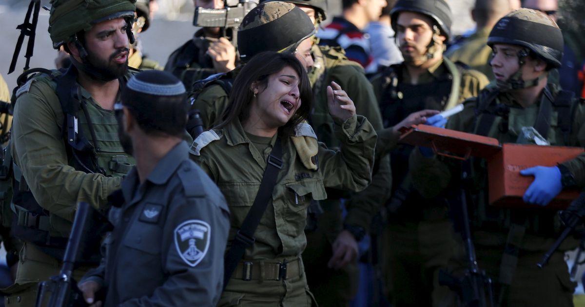 Ізраїльська жінка-солдат плаче після того, як палестинець напав з ножем і вбив  її товариша по службі на автозаправній станції, перш ніж він був застрелений військовими недалеко від села Кібріт Аль-Місбах на Західному березі Йордану між Єрусалимом і Тель-Авівом. / © Reuters