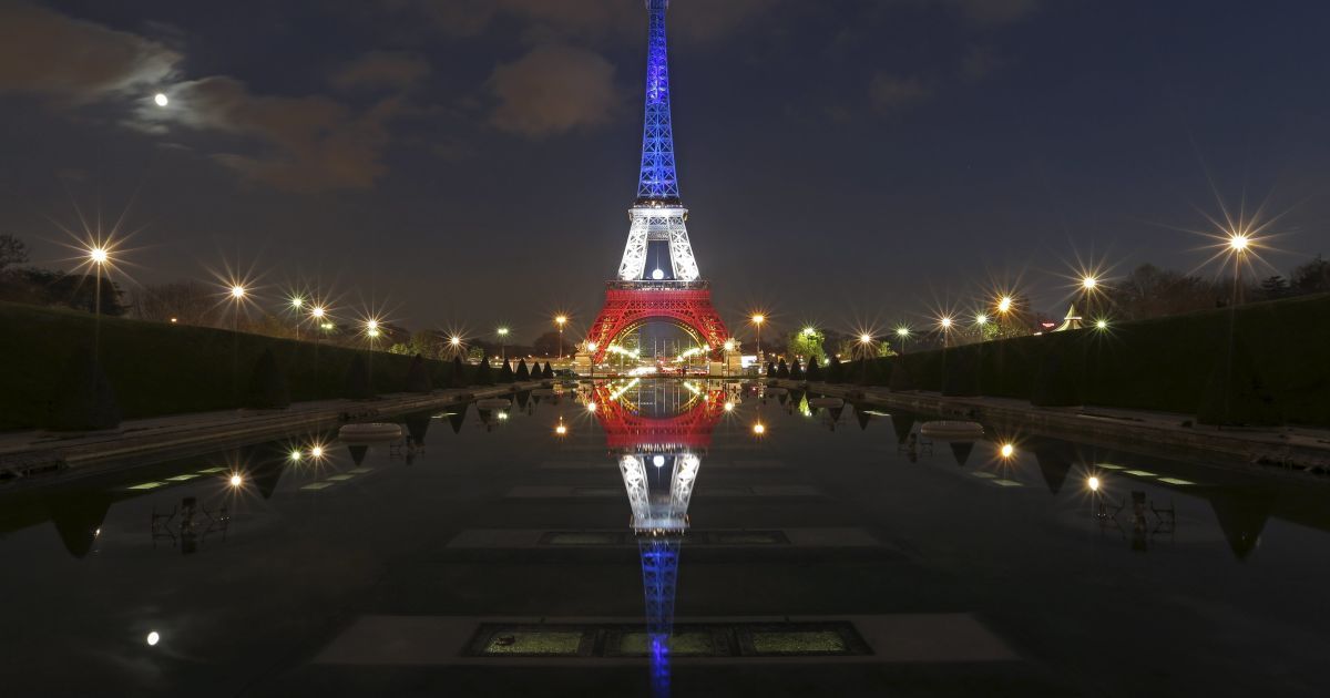 Світло від Ейфелевої вежі, яка горить блакитним, білим і червоним кольорами французького прапору, відбивається у фонтанах Трокадеро в Париж через 10 днів після серії смертельних атак в столиці Франції. / © Reuters