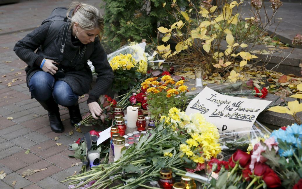 Люди несут цветы и свечи / © Reuters