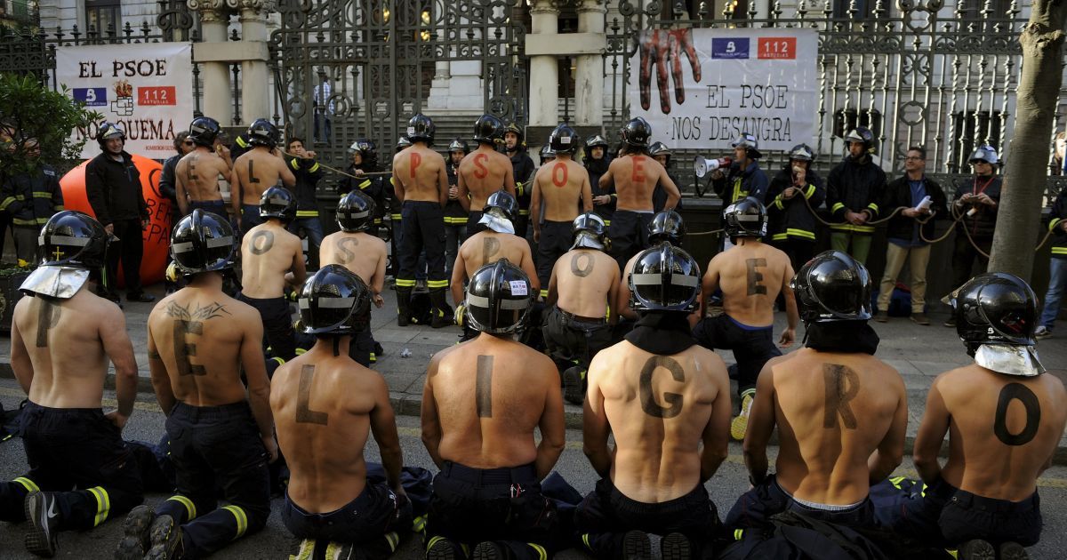 Пожежники беруть участь в акції протесту перед регіональним парламентом Астурії, Іспанія, вимагаючи більш високої заробітної плати і посилення норм громадської безпеки. Букви, написані на чоловічих спинах, утворюють слова, які читаються як "PSOE (Соціалістична партія Іспанії) ставить вас у небезпеку". / © Reuters