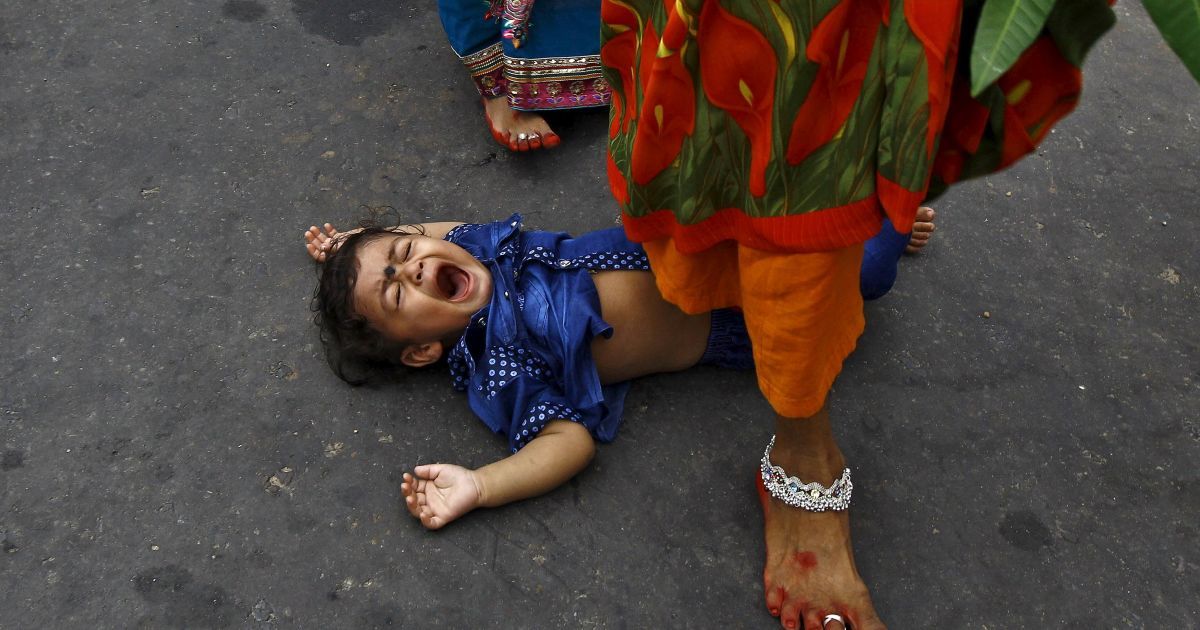 Жінка наступає на дитину під час ритуалу благословення від бога Сонця Сурья під час індуїстського релігійного свята Чатт Пуджа в Калькутті, Індія. Індійські жінки протягом цілого дня виконують різні ритуали задля поліпшення благополуччя їхніх родин. / © Reuters