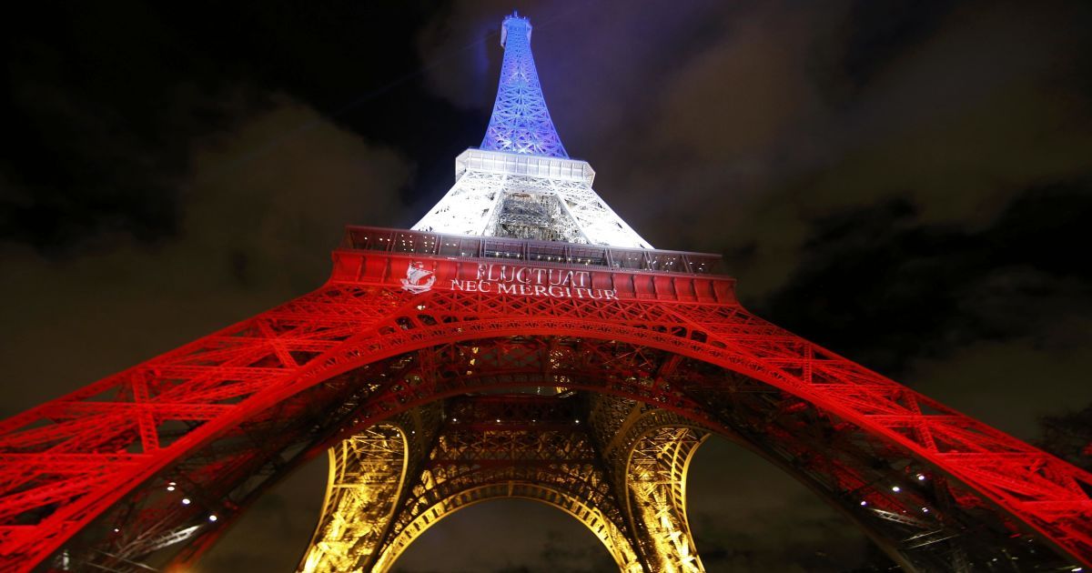 Ейфелева вежа горить блакитним, білим і червоним кольорами французького прапора в Парижі, щоб віддати належне жертвам серії смертоносних нападів в п'ятницю в столиці Франції. / © Reuters