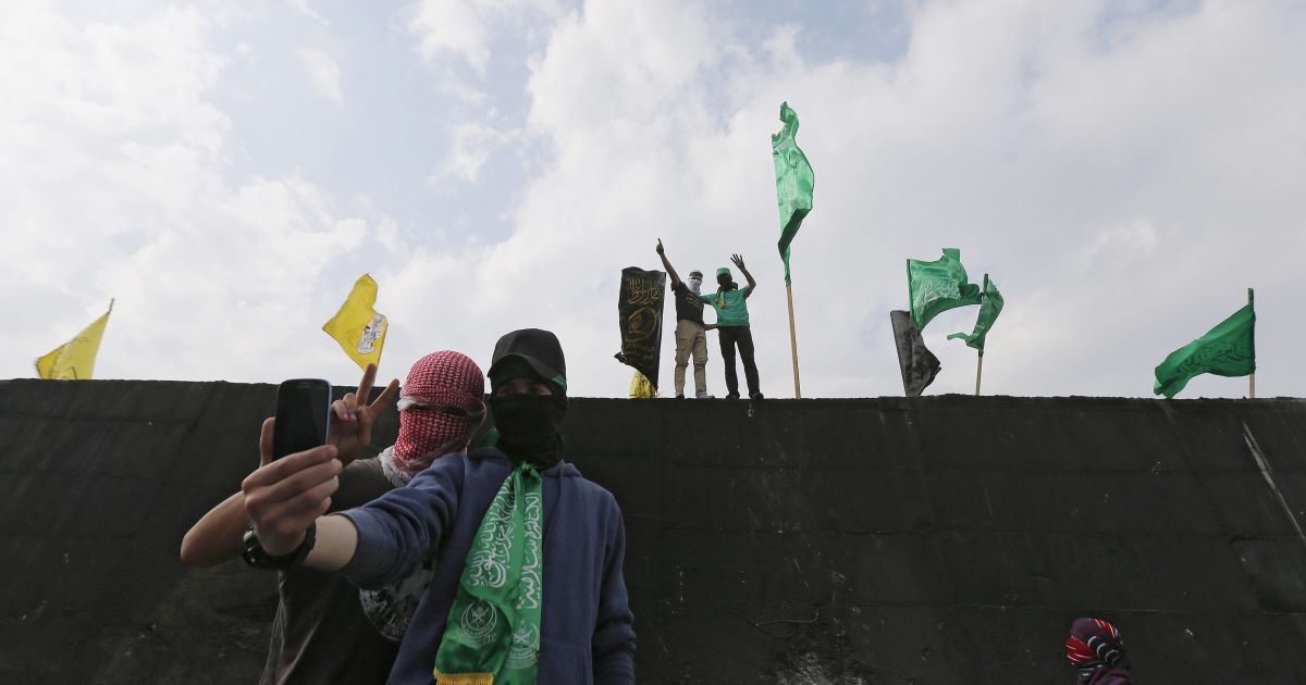 Палестинські демонстранти знімають селфі перед секцією ізраїльської стіни, яка відокремлює місто Абу-Діс з Єрусалимом, під час антиізраїльської акції протесту. / © Reuters