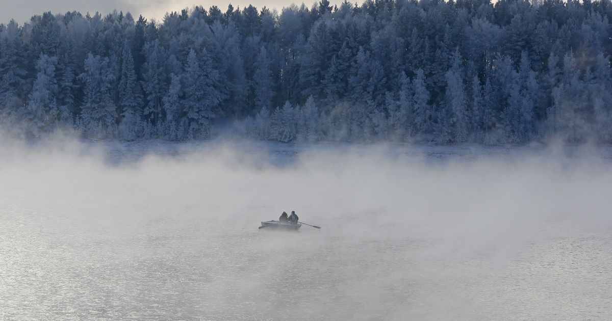 Двоє чоловіків гребуть на човні через морозний туман вздовж річки Єнісей при температурі повітря мінус 20 градусів Цельсія в районі тайги за межами сибірського міста Красноярськ, Росія. / © Reuters