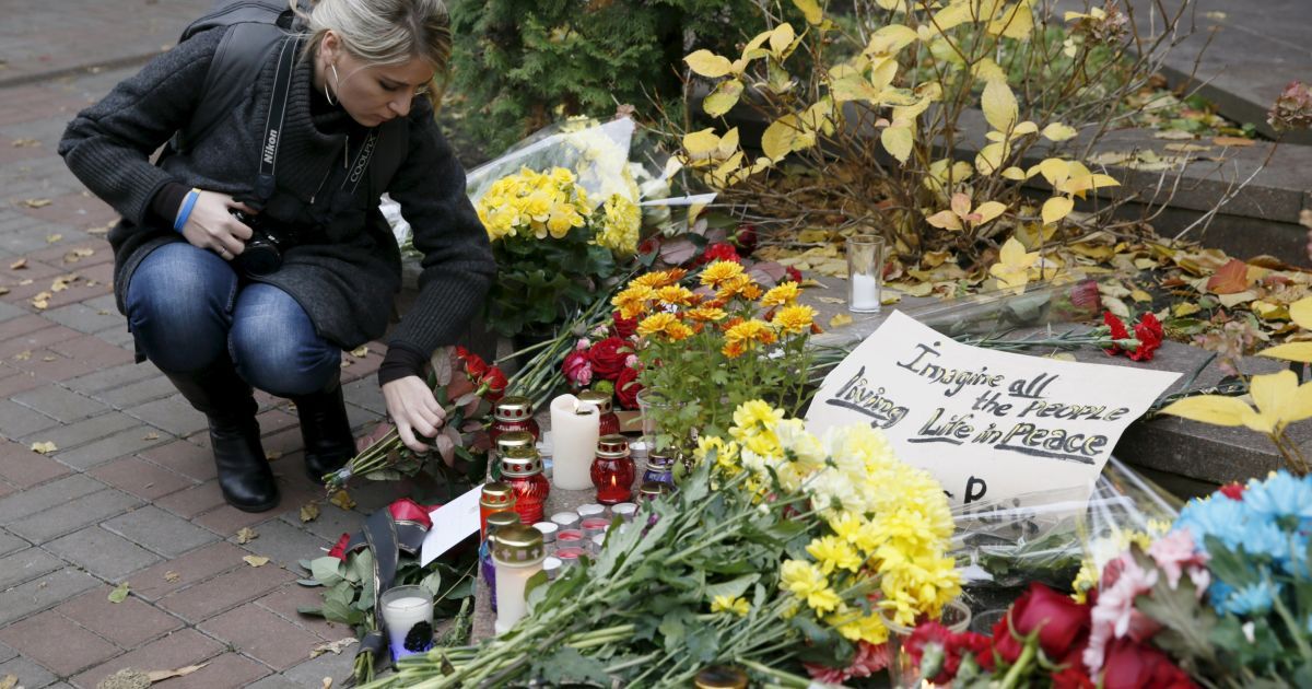 Люди несут цветы и свечи / © Reuters