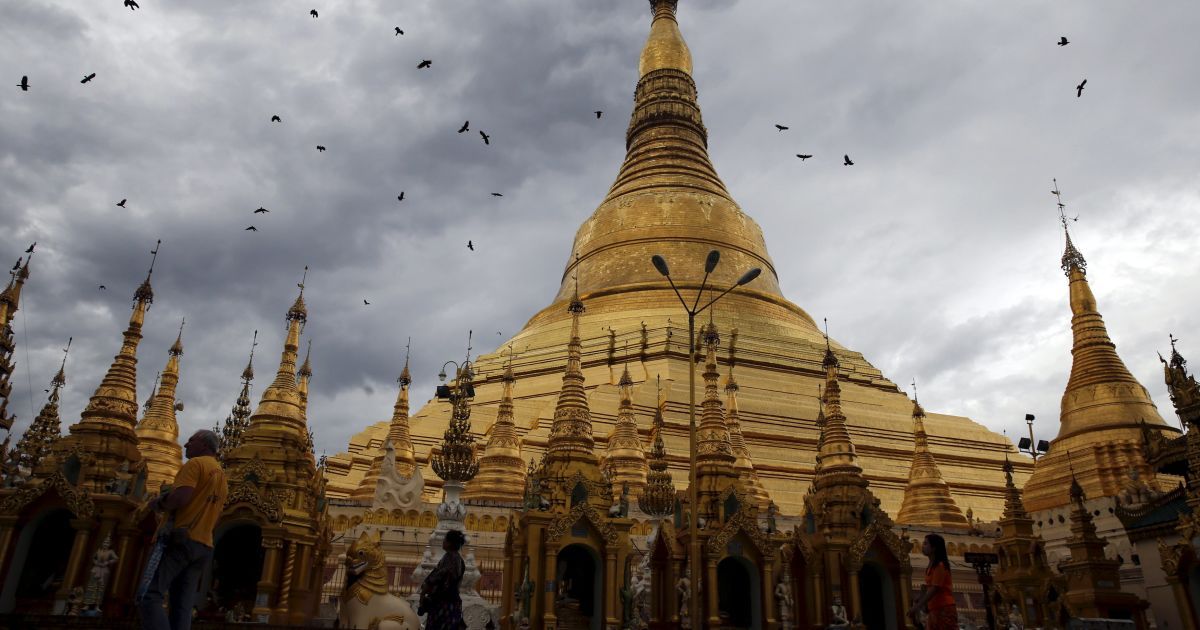 Фотограф зняв, як люди ходять біля пагоди Шведагон в Янгоні, М'янма. / © Reuters