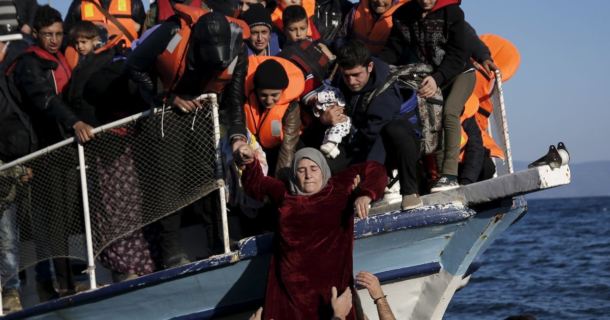 Жінці-мігранту допомагають покинути човен, на якому біженці прибувають на грецький острів Лесбос. З початку року понад 590 000 мігрантів чоловік дісталися Греції, тікаючи від війни у Сирії. / © Reuters