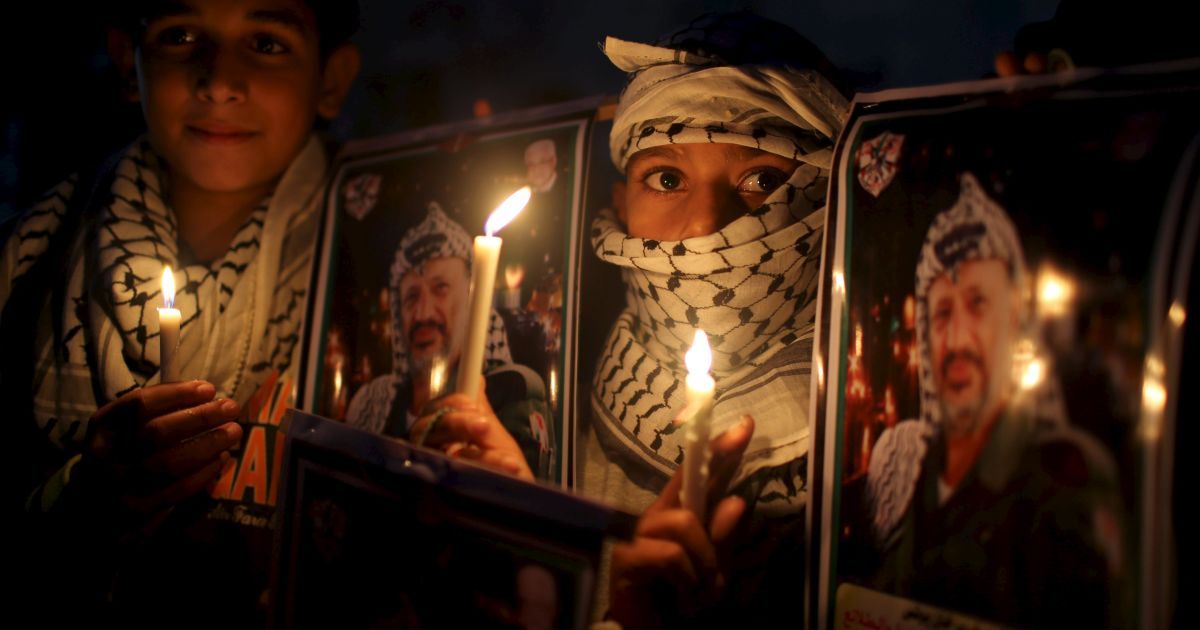 Палестинські хлопчики тримають свічки під час акції з нагоди 11-ї річниці з дня смерті палестинського лідера Ясира Арафата, і містечку Хан-Юніс на півдні сектора Газа. Арафат помер 11 листопада 2004 року. / © Reuters