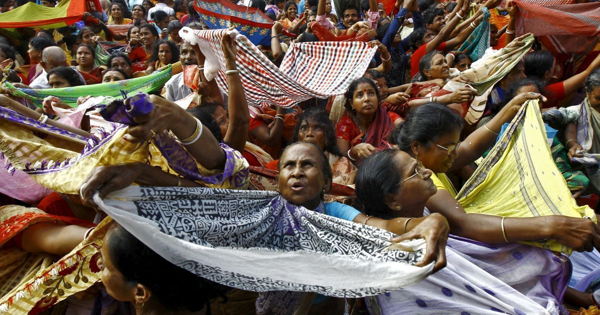 Індуїстські віруючі тримають шарфи, щоб отримати рис, який роздають у храмі з приводу фестивалю Аннакут у Калькутті, Індія. Аннакут відзначається в перший день повного місяця, під час свята 56 типів продуктів харчування роздаються віруючим. / © Reuters