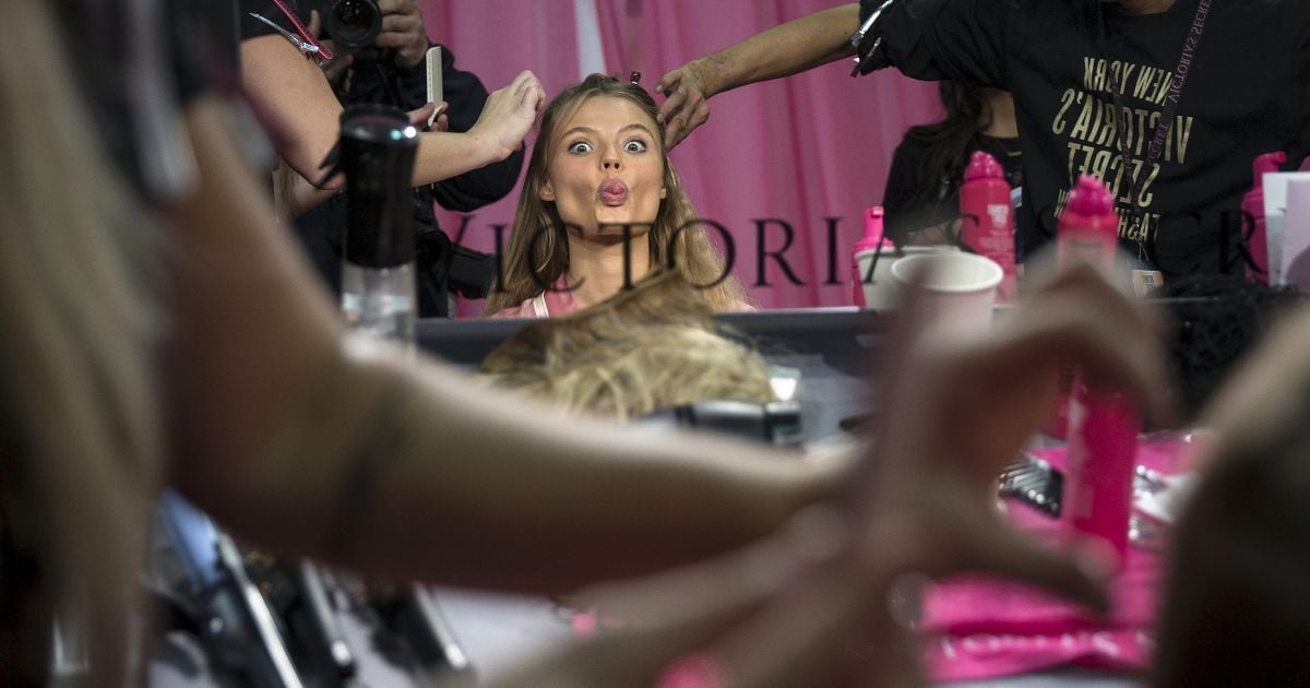 Модель висовує язик у той час, як їй роблять зачіску за лаштунками перед заходом Victoria Secret Fashion Show у Манхеттені, Нью-Йорк. / © Reuters