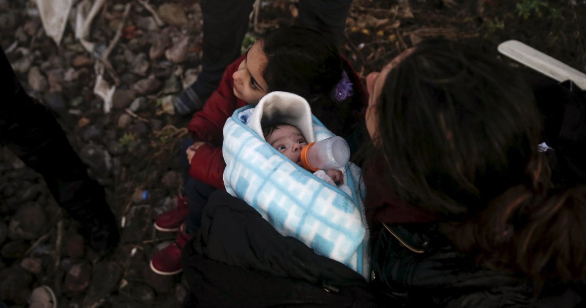 Сирійська біженка годує своє немовля після того, як мігранти прибули на човні на грецький острів Лесбос. З початку року понад 590 000 біженців прибули до Греції, тікаючи від війни у Сирії. / © Reuters