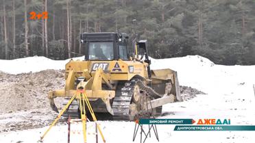 Зимовий ремонт: десяток робітників кидає асфальт у ями на заледенілій дорозі
