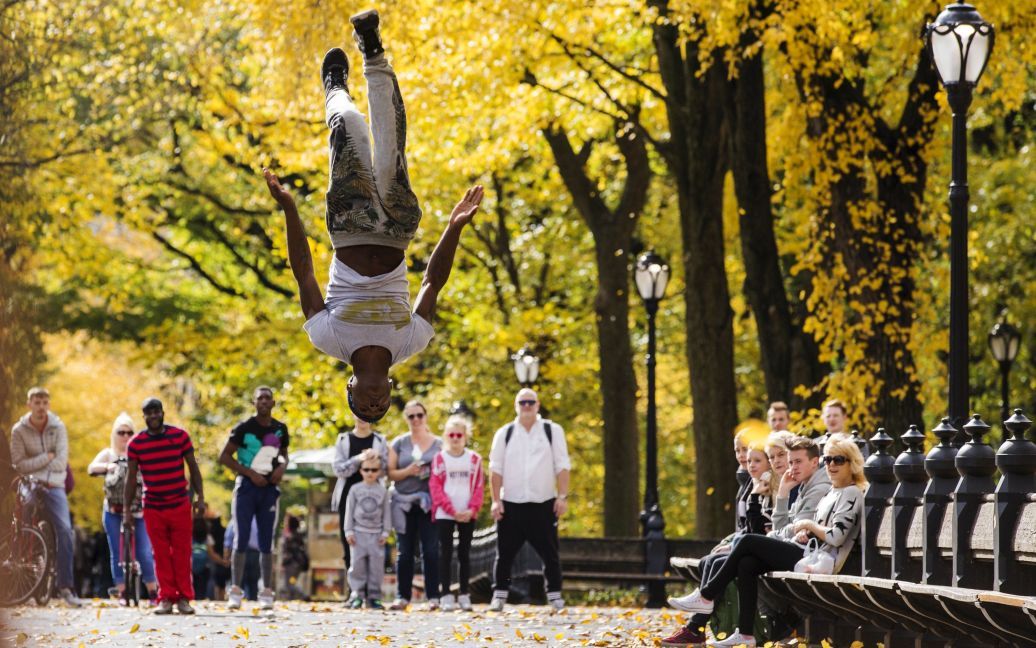 Уличный исполнитель прыгает в воздухе в Центральном парке Нью-Йорка. / © Reuters
