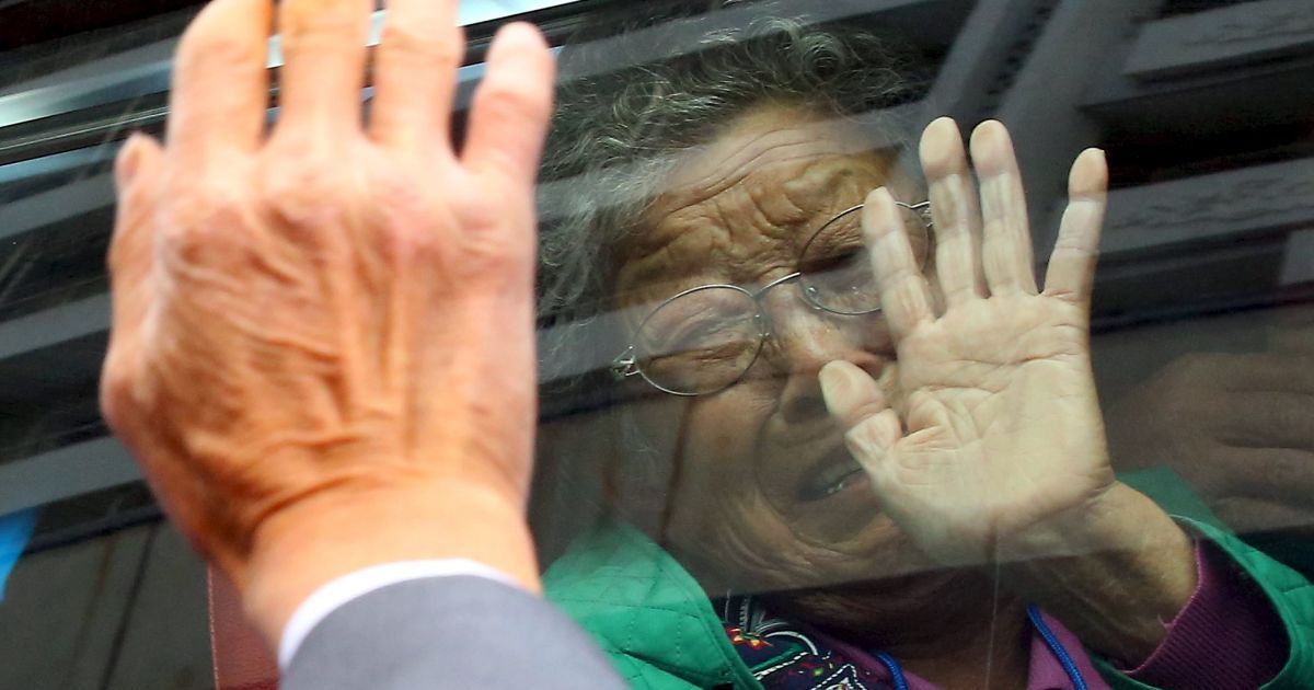 Северокореец Юнг Кун Мок, бывший рыбак, который был похищен в Северной Корее несколько десятилетий назад, и его южнокорейская мать Ли Бок-Сан (внутри автобуса) прощаются друг с другом после встречи разделенных семей на курорте Кымган, Северная Корея. Почти 400 южнокорейцев пересекли границу, чтобы соединиться на несколько дней с членами своих семей, разлученных во время корейской войны 1950-53 годов.