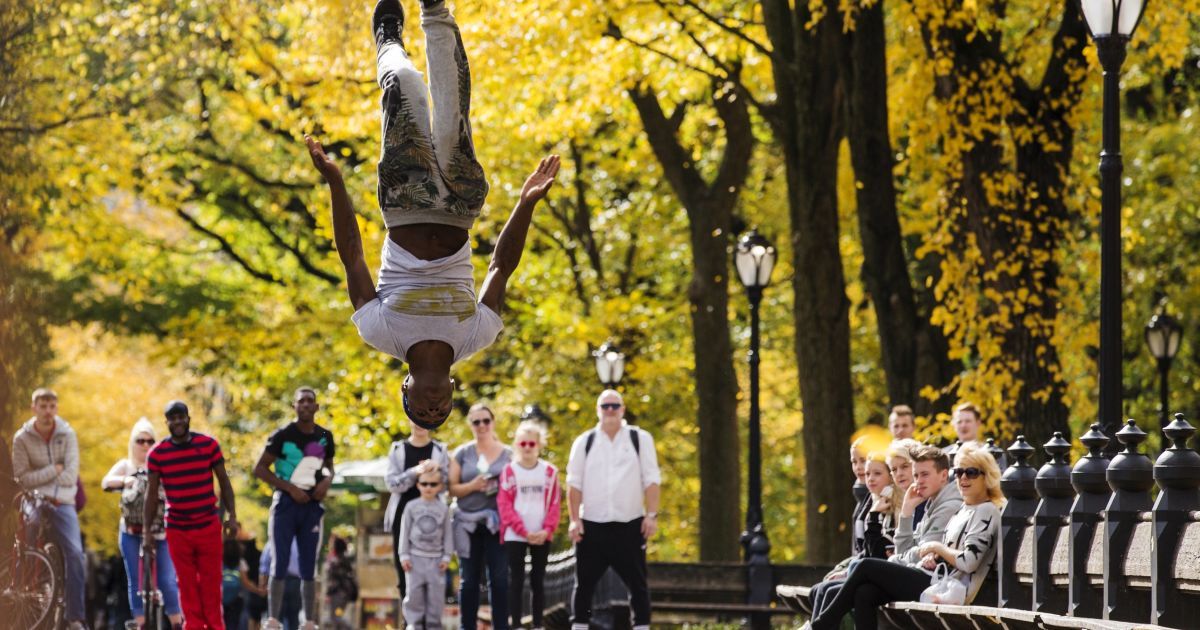 Уличный исполнитель прыгает в воздухе в Центральном парке Нью-Йорка. / © Reuters
