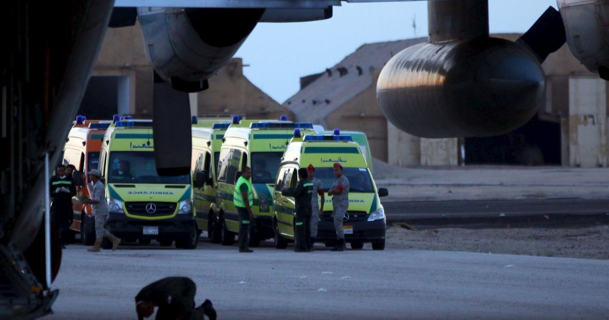 Чоловік молиться на тлі рятувальників, які працюють на місці падіння літака. / © Reuters