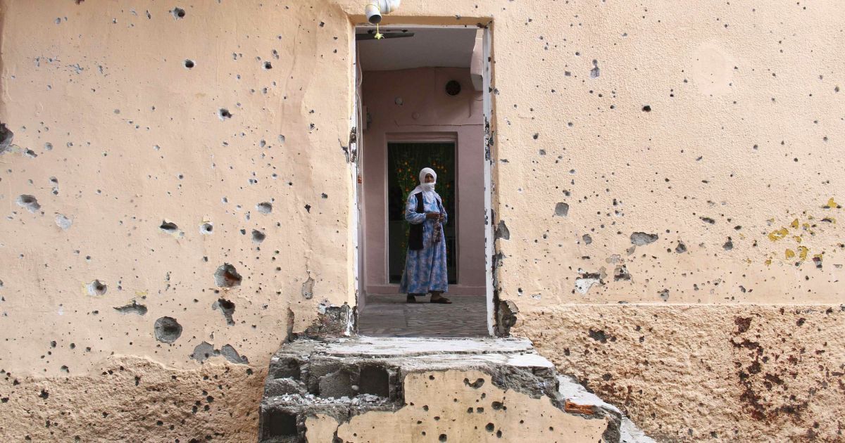 Жінка йде всередині пошкодженого кулями будинку у турецькому місті Діярбакир, переважно населенному курдами. У Туреччині 1 листопада відбудуться дострокові вибори до парламенту і президент Тайіп Ердоган сподівається, що його Партія справедливості поверне собі більшість, яку вона втратила п'ять місяців тому. / © Reuters