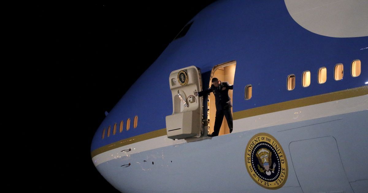 Стюард открывает двери в самолете авиакомпании Air Force One, чтобы посмотреть, как президент США Барак Обама прибывает на базу "Эндрюс" в штате Мэриленд. / © Reuters