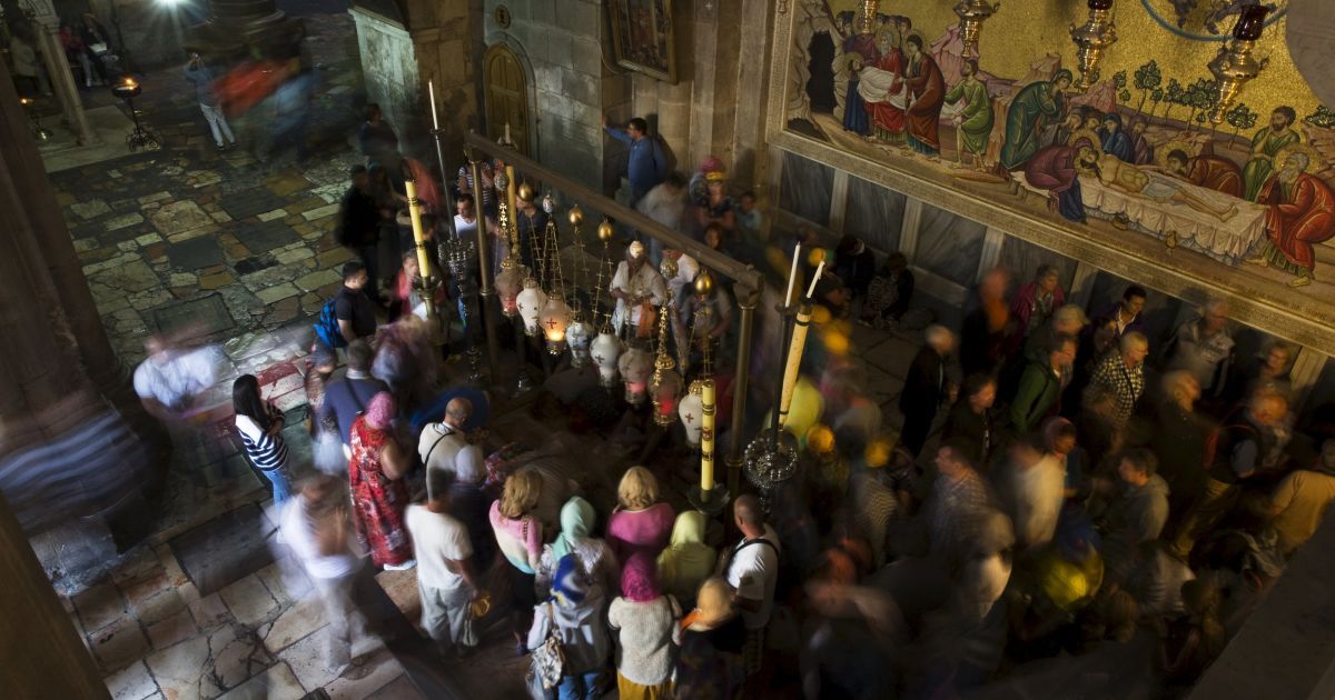 Туристы посещают церковь Гроба Господня в Старом Иерусалиме. 2 октября недалеко отсюда палестинский студент права убил ножом двух израильтян. Это было одно из первых нападений в волне насилия, которая унесла жизни 11 израильтян и 61 палестинцев, в том числе 34 убитых нападавших. / © Reuters