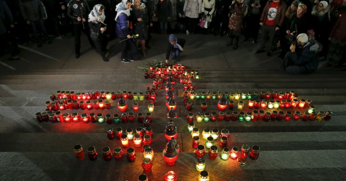 Люди возлагают цветы у креста с 224 свечей на ступеньках храма Христа Спасителя в Москве в память о жертвах российского авиалайнера. Самолет потерпел крушение 31 октября в Египте, никто из пассажиров и членов экипажа не вижил. / © Reuters
