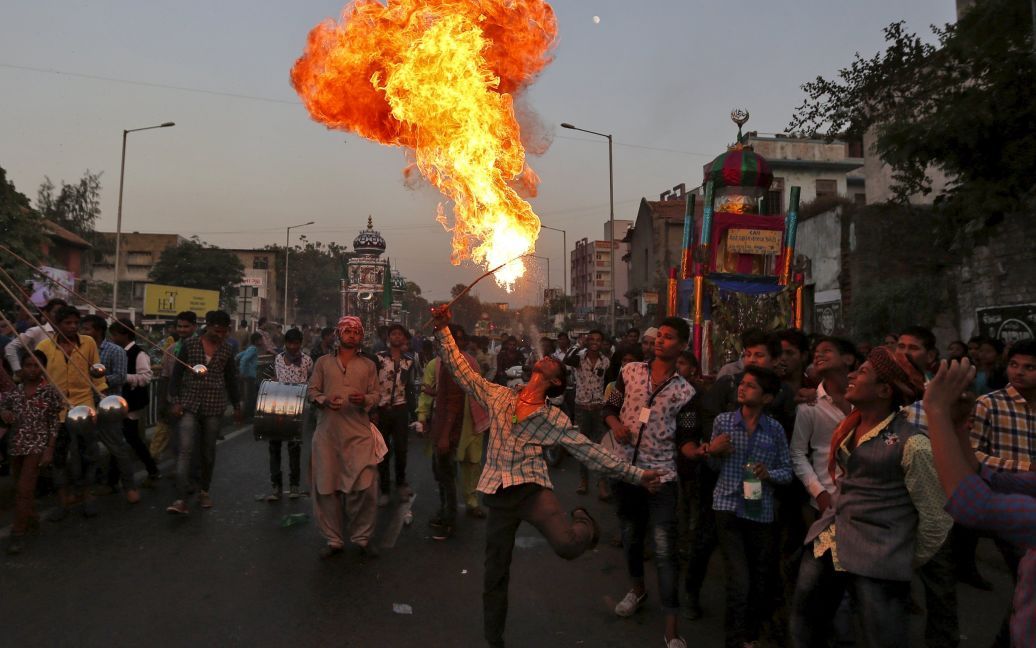 Человек выступает с огнем во время процессии в честь Ашура в Ахмедабаде, Индия. Этот праздник отмечается в память о гибели имама Хусейна, внука пророка Мухаммеда, который был убит в битве при Кербеле в 7 веке. / © Reuters
