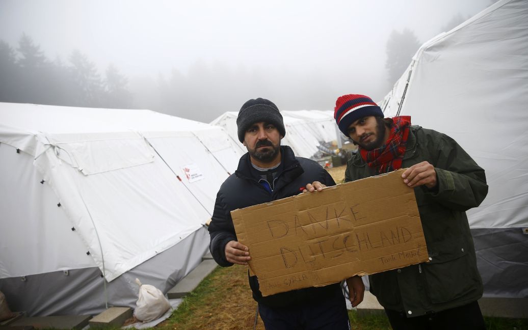Мигранты из Сирии держат табличку с надписью "Спасибо, Германия". 350 беженцев проживают в палатках во временном миграционном центре в деревне близ Франкфурта. / © Reuters