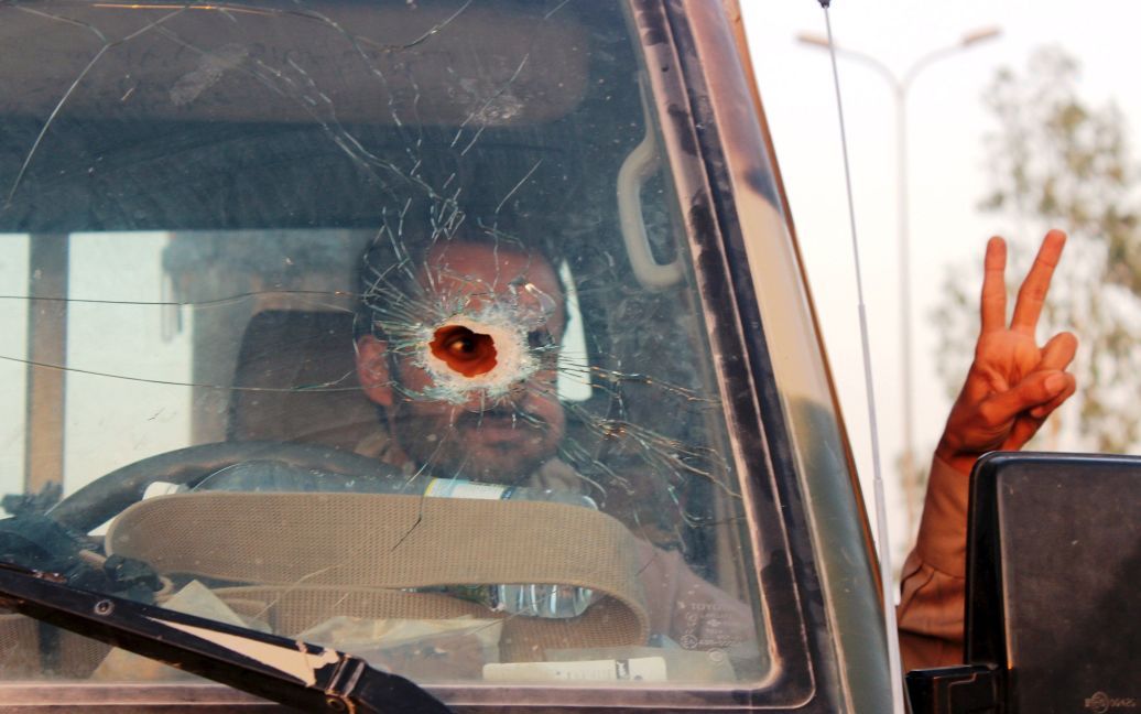 Йеменского солдата сфотографировали через лобовое стекло автомобиля, поврежденного пулей. В Йемене продолжается гражданская война, которая уже унесла жизни более 4500 человек. / © Reuters