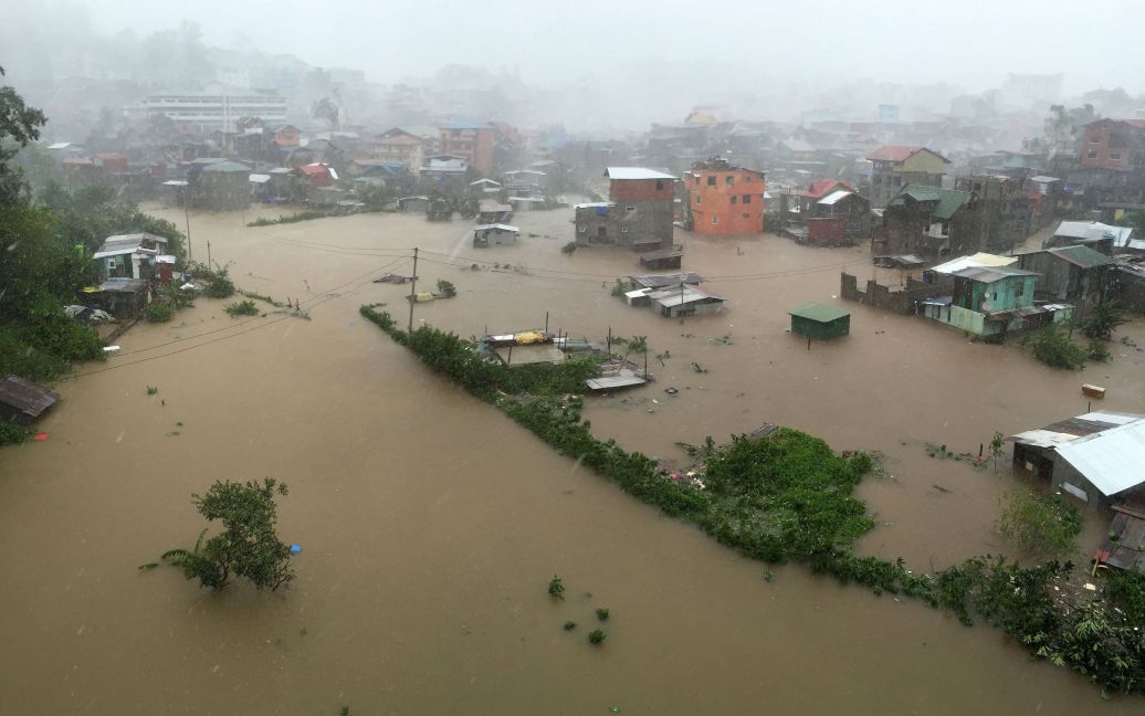 Дома, частично погруженные в водах наводнения, вызванного проливными дождями, которые принес тайфун Kоппу в Филиппинах. Тайфун убил по меньшей мере девять человек, а десятки тысяч людей были эвакуированы. / © Reuters