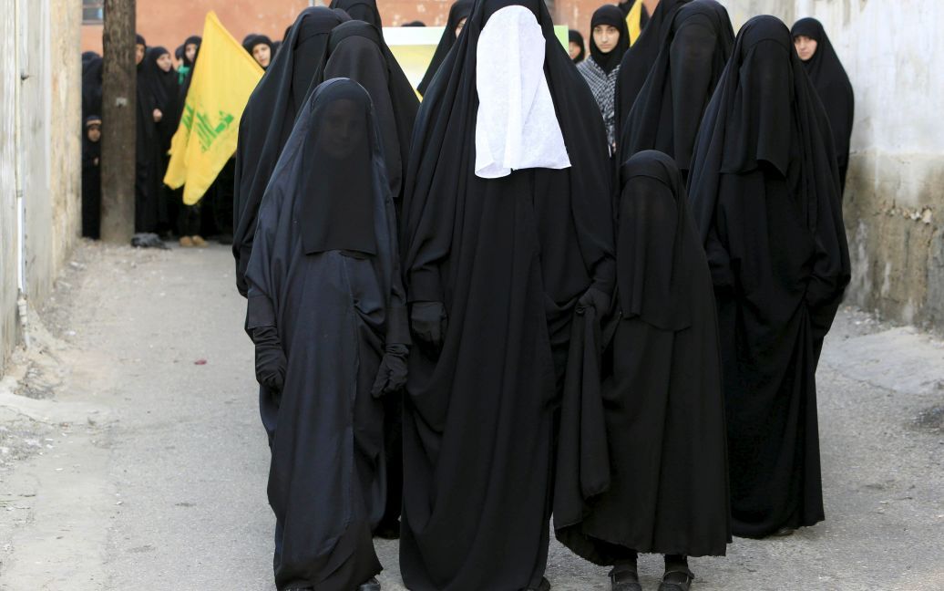 Мусульманские шиитские женщины и девочки несут флаги "Хезболлы" во время марша в честь годовщины битвы при Кербеле. Это самый важный день в шиитском календаре, когда чествуют память о смерти имама Хусейна, внука пророка Мухаммеда. / © Reuters