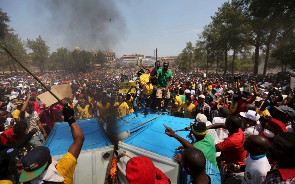 Протестующие скандируют лозунги во время акции протеста против запланированного увеличения платы за обучение в Южно-Африканской Республике. 23 октября полиция применила шумовые гранаты и водометы, чтобы разогнать демонстрантов. / © Reuters