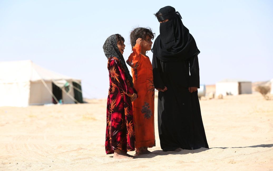 Девушки стоят в лагере для беженцев в северо-западной провинции Йемена Аль-Джауфе, которую контролируют повстанцы хуситы. С марта между хуситами и правительственными войсками, которых поддерживает Саудовская Аравия, идет гражданская война. Конфликт унес жизни по меньшей мере 4500 человек. / © Reuters