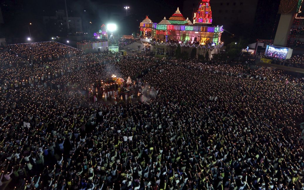 Индуистские верующие держат глиняные лампы и факелы во время молитвы по случаю праздника Наваратри в городе Сурат, Индия. Индуисты поклоняются богине Дурга во время фестиваля, который длится девять ночей. / © Reuters