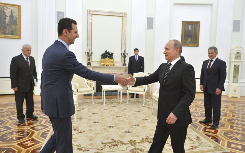 Президент России Владимир Путин пожимает руку президенту Сирии Башару Асаду во время встречи в Кремле в Москве. Асад сделал неожиданный визит в Москву во вторник вечером, чтобы поблагодарить Путина за авиаудары по исламистам в Сирии. / © Reuters