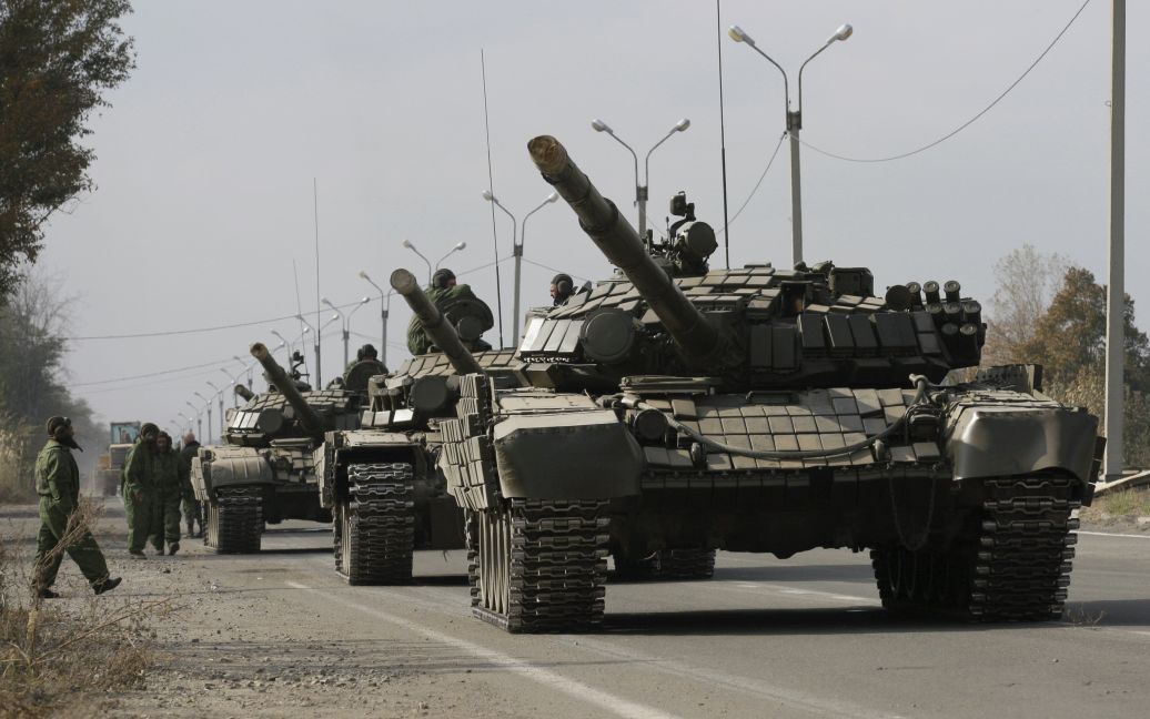 Боевики под наблюдением представителей ОБСЕ отводят танки. / © Reuters
