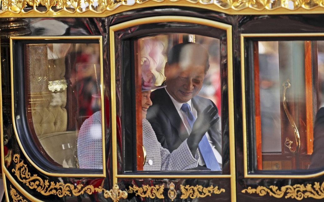 Королева Великобритании Елизавета и президент Китая Си Цзиньпин едут в карете в Букингемский дворец в Лондоне. Си Цзиньпин с женой встретились с королевой во время их государственного визита в Великобританию. / © Reuters