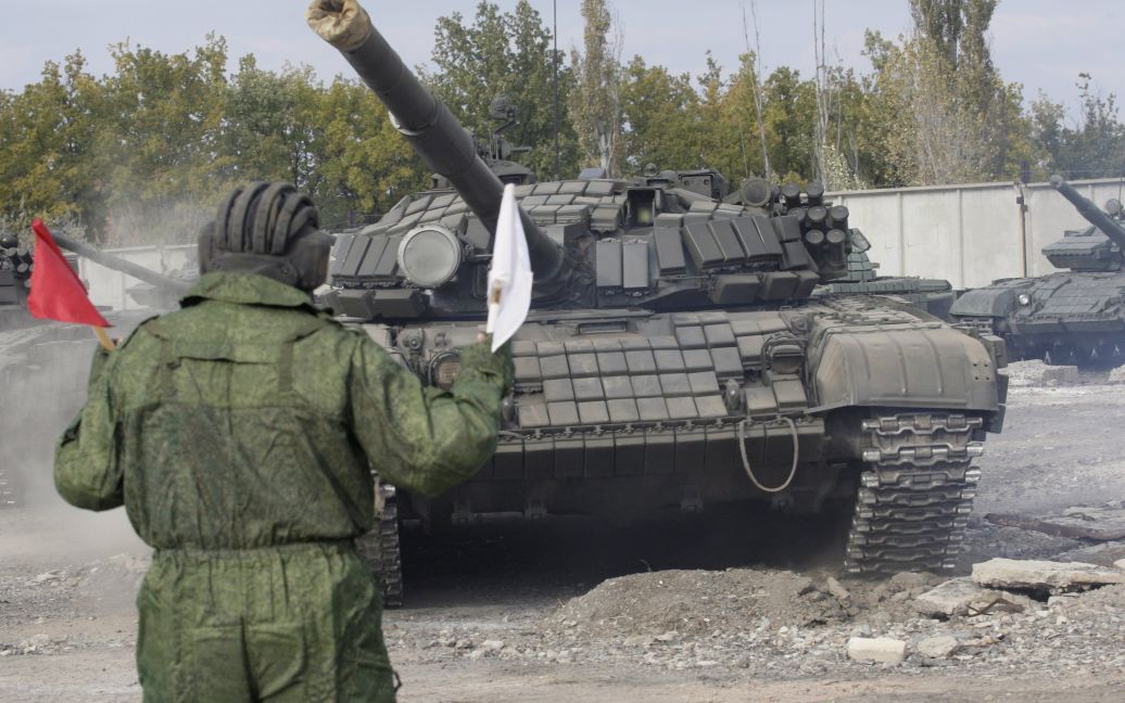 Боевики под наблюдением представителей ОБСЕ отводят танки. / © Reuters