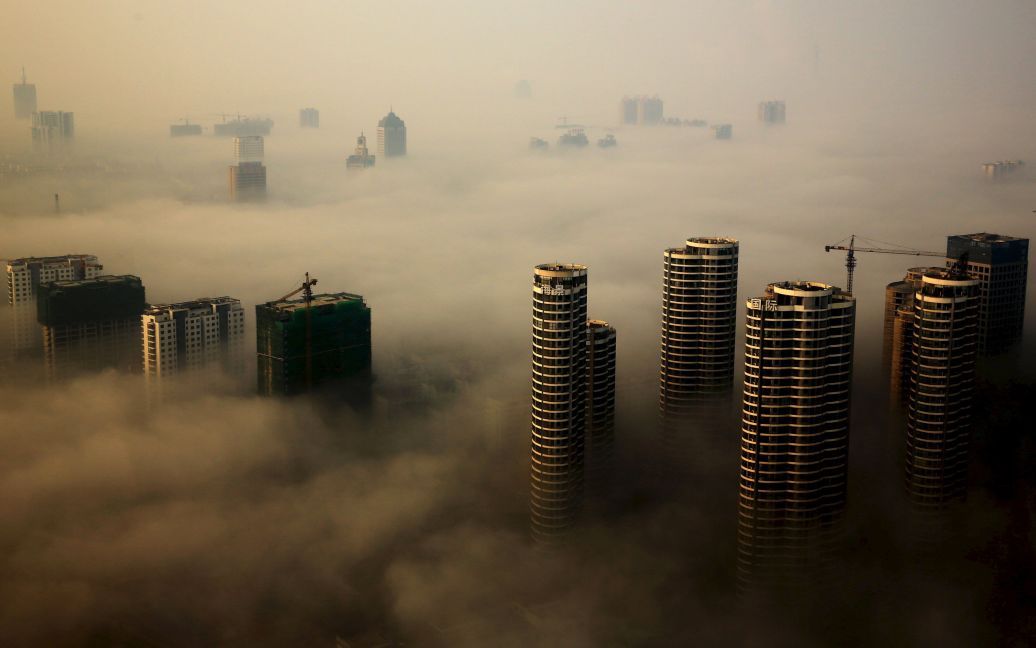 Небоскребы видны среди тумана в городе Жичжао, провинция Шаньдун, Китай. / © Reuters