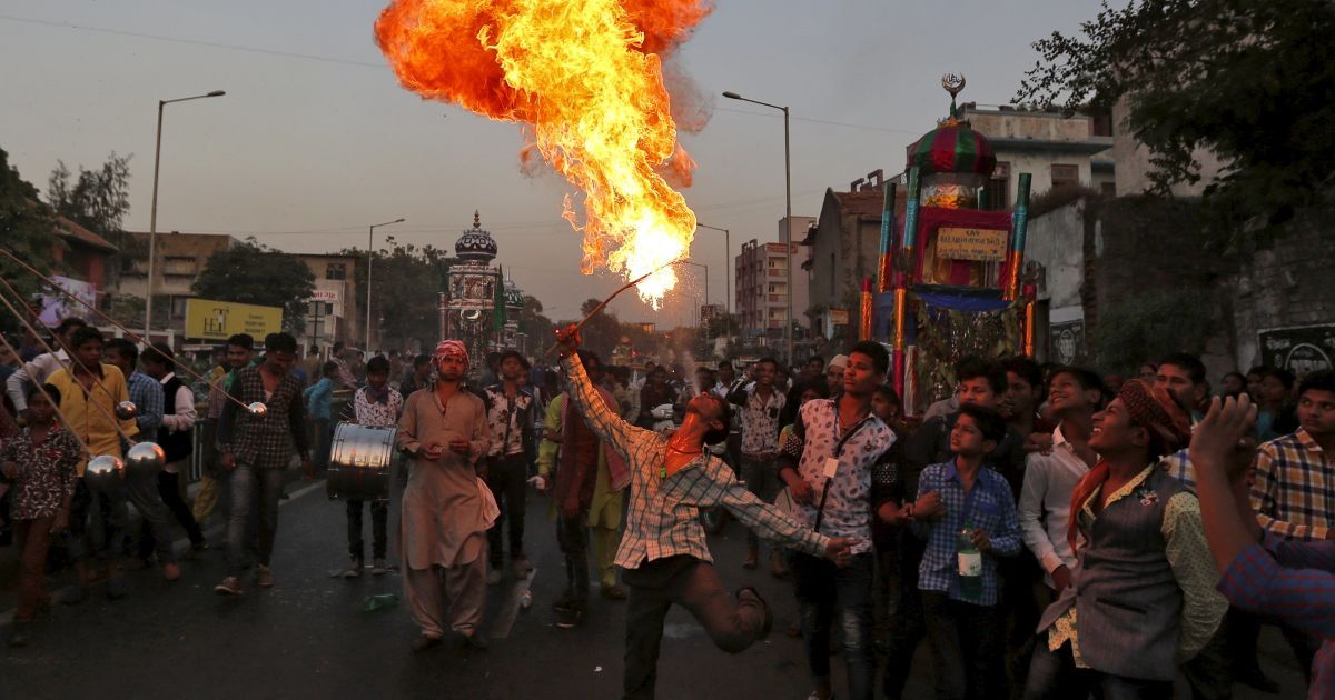 Человек выступает с огнем во время процессии в честь Ашура в Ахмедабаде, Индия. Этот праздник отмечается в память о гибели имама Хусейна, внука пророка Мухаммеда, который был убит в битве при Кербеле в 7 веке. / © Reuters