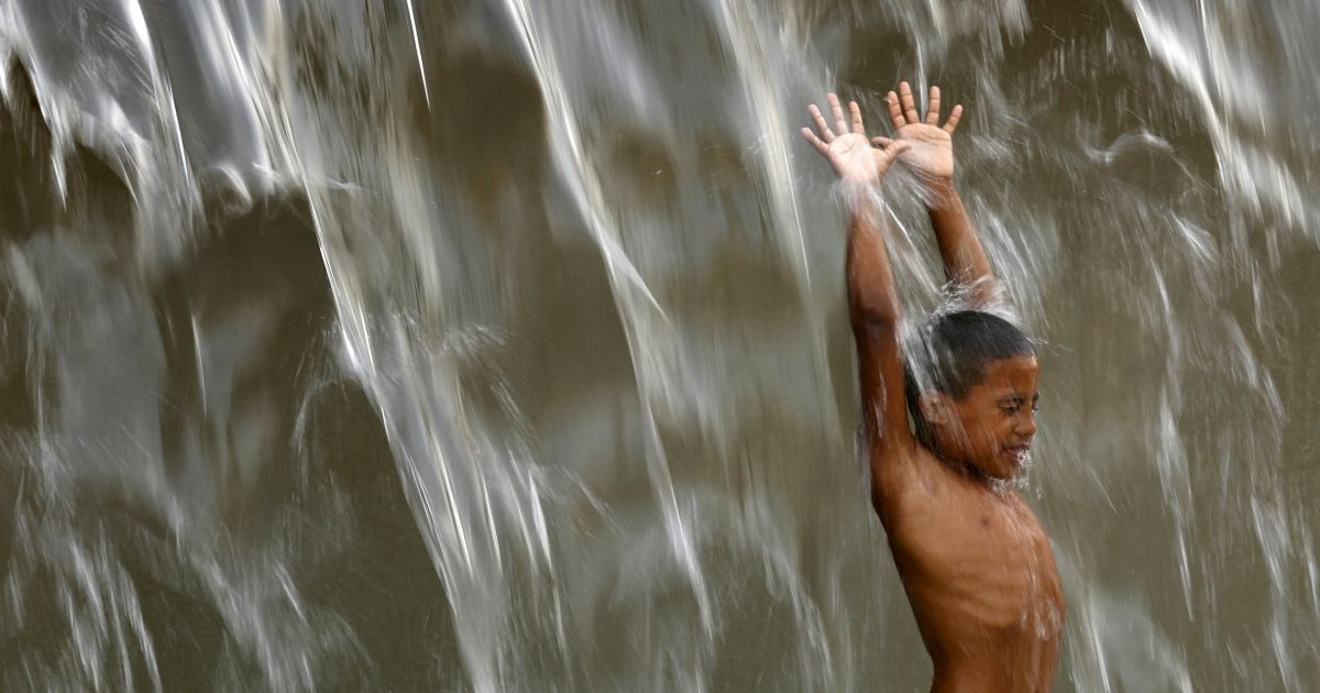Мальчик купается в общественном фонтане в Рио-де-Жанейро, Бразилия. Температура в городе достигла 42,8 градусов по Цельсию, что является рекордом за последние 100 лет. / © Reuters