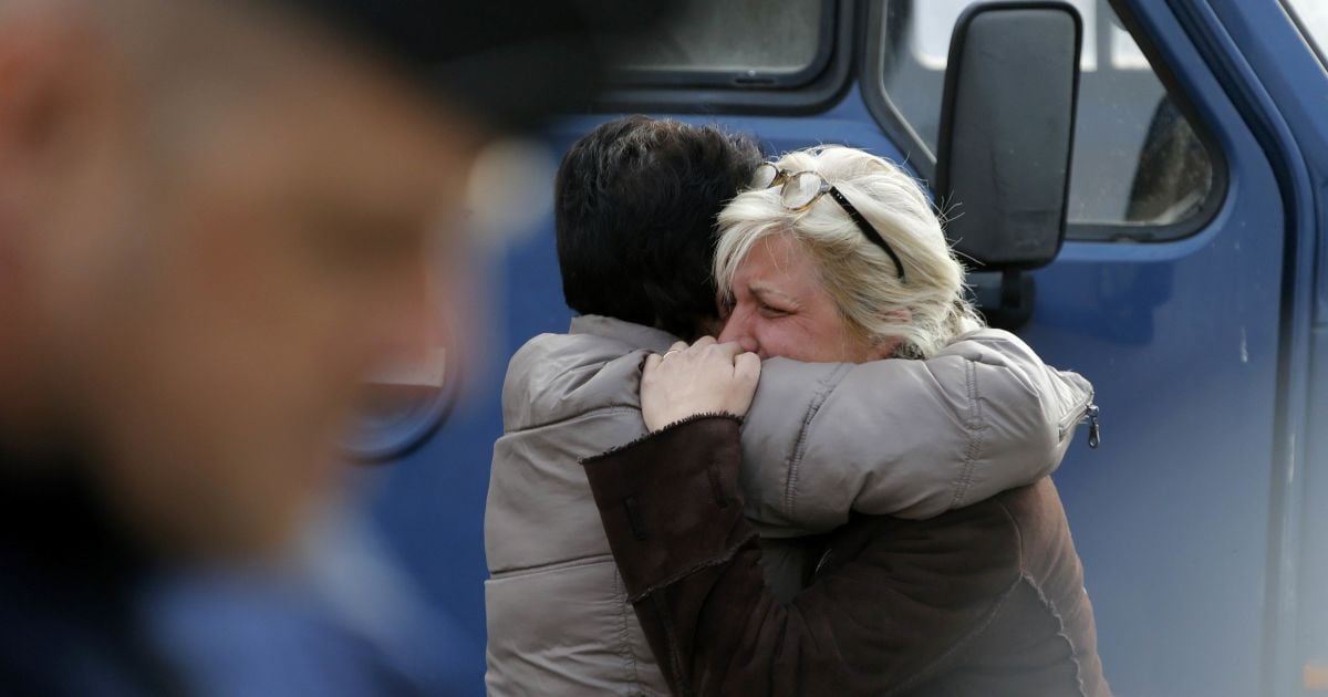 Люди утешают друг друга за пределами центра экстренной терапии во время спасательных операций в районе того места, где пассажирский автобус столкнулся с грузовиком близ города Бордо, Франция. В результате аварии погибли 42 человека. / © Reuters