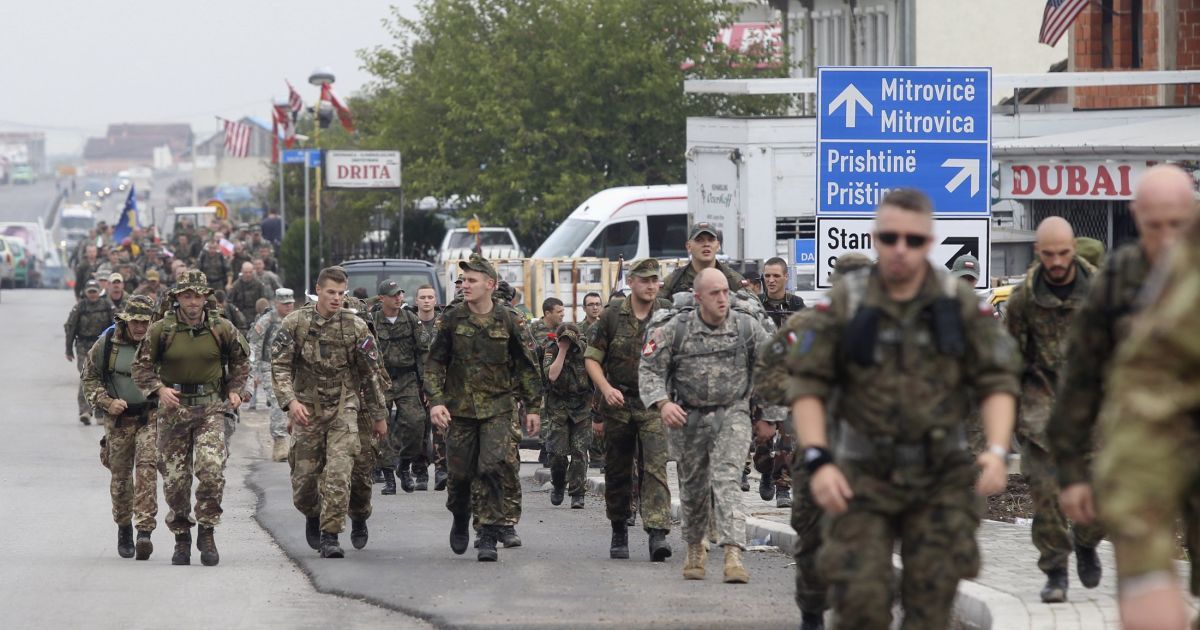 Солдаты с миротворческой миссии НАТО в Косово маршируют за пределами их лагеря недалеко от города Вуштри, в северной части Косово. Такой марш с 1972 года является датской военной традицией знакомства, когда иностранные военные ходят вместе 25 километров. / © Reuters