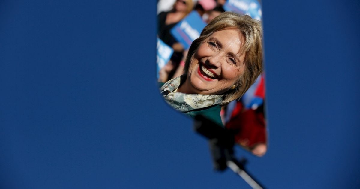 Кандидат в президенты США от Демократической партии Хиллари Клинтон отражается в стеклянном суфлере во время встречи со сторонниками в Александрии, штат Вирджиния. / © Reuters