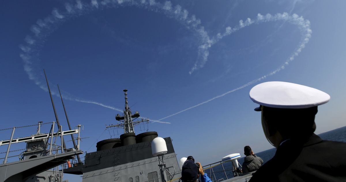 Военный японских морских сил самообороны смотрит на выступление Воздушных сил самообороны Японии во время выступления флота вблизи города Йокосука, к югу от Токио. / © Reuters